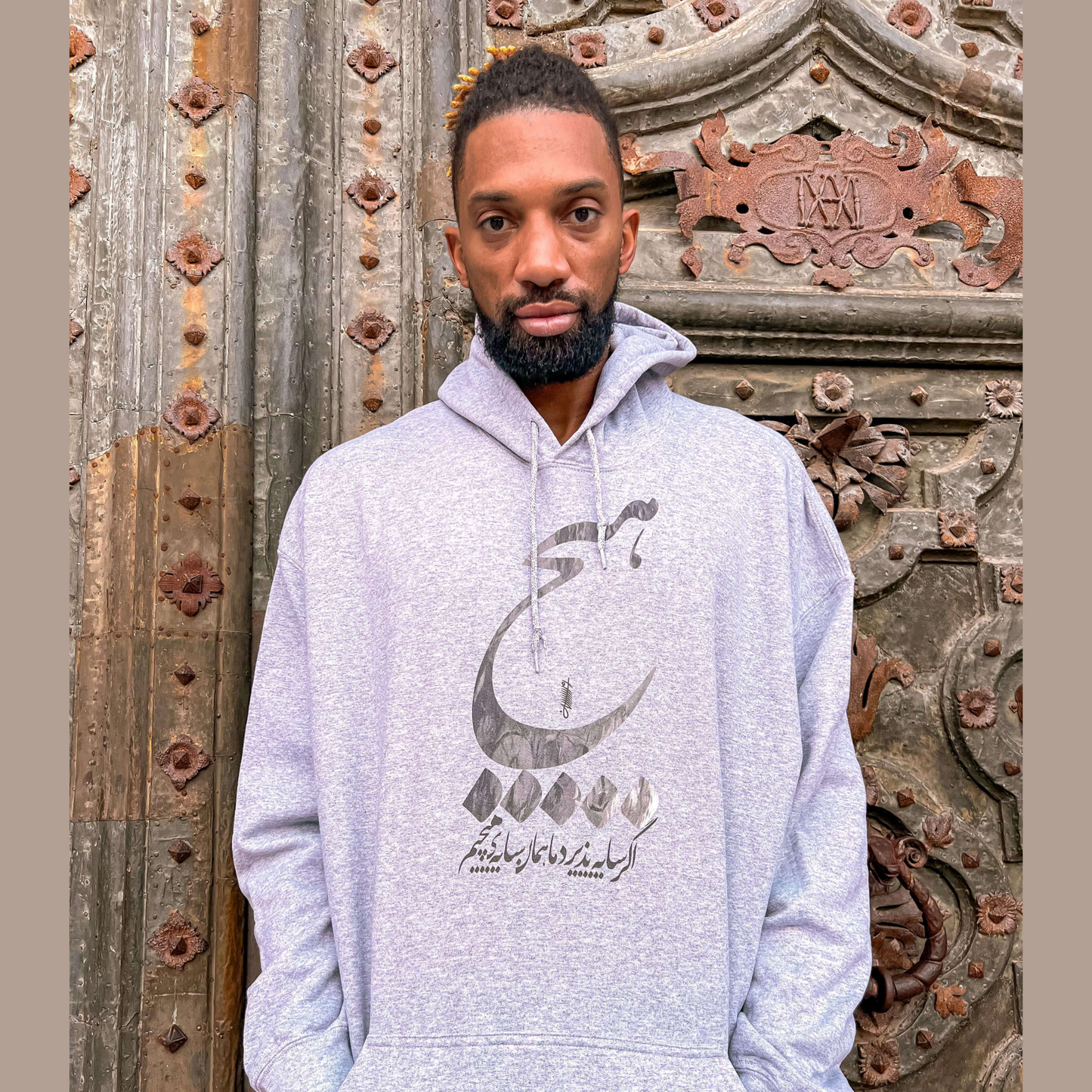 Unisex gray hoodie featuring bold ‘Hich’ (هیچ) Persian calligraphy design – modern Farsi typography streetwear sweatshirt, minimalist calligraphy fashion, unique graphic hoodie for men and women in USA and Canada.