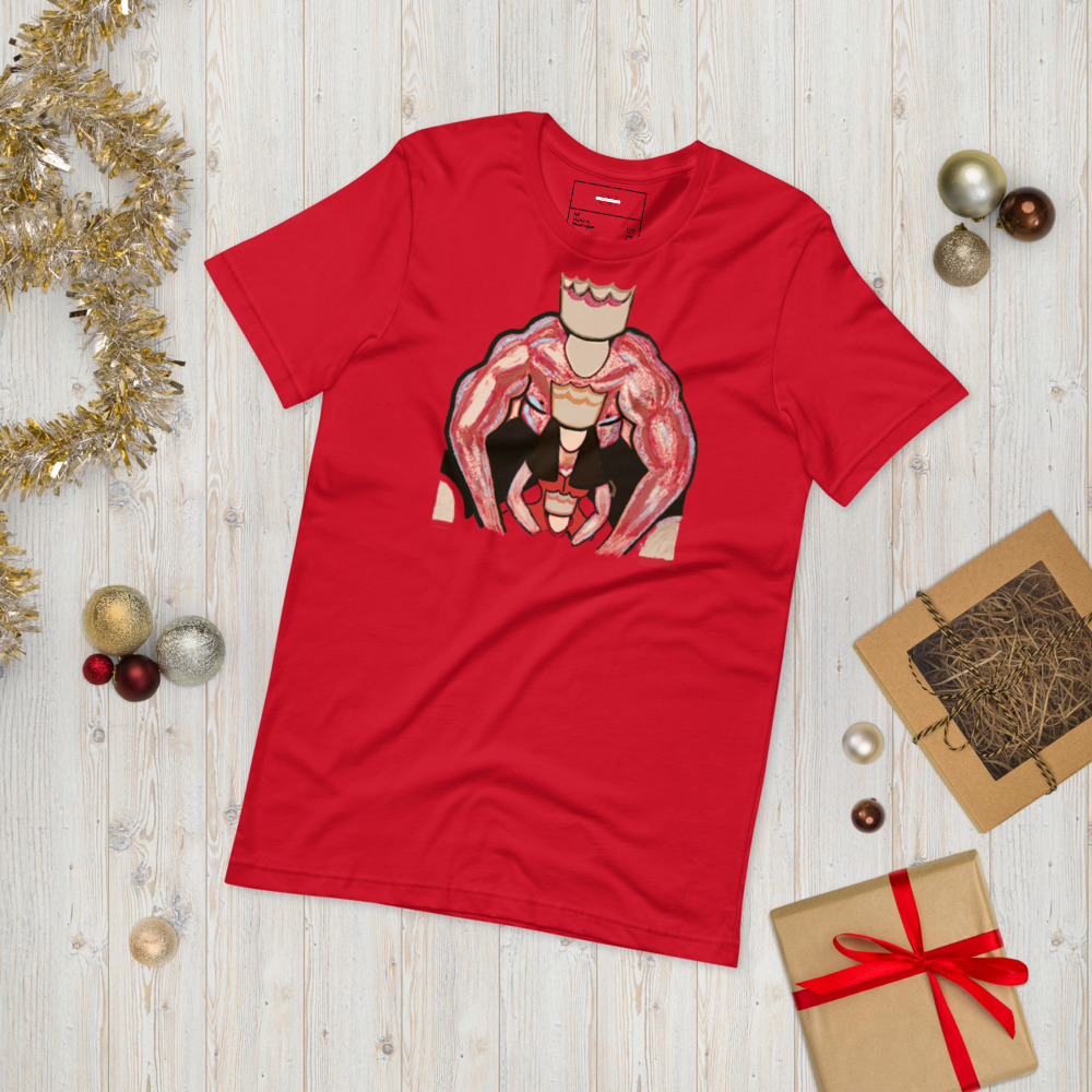 Red t-shirt with a striking graphic design featuring a muscular king and queen in a powerful embrace, displayed on a light wooden background with festive decorations and gift boxes.