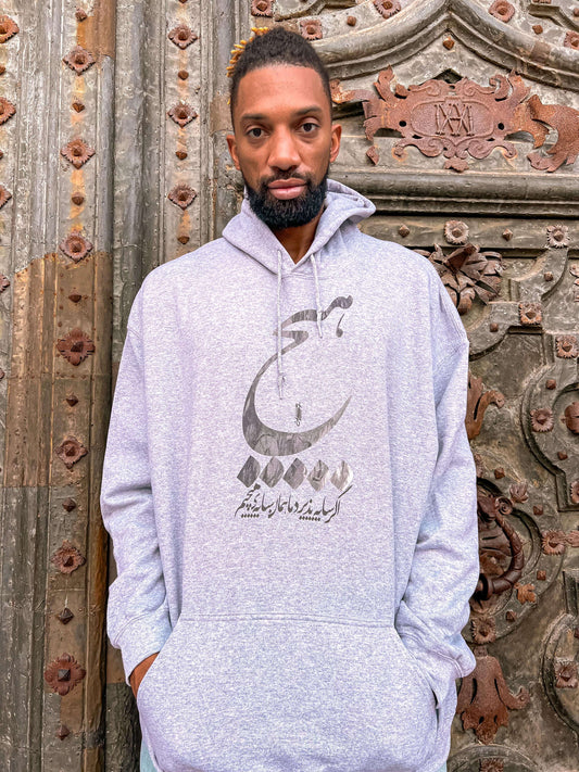khem Birch wearing Persian-inspired hoodie with the word "هیچ" (nothing) emblazoned.