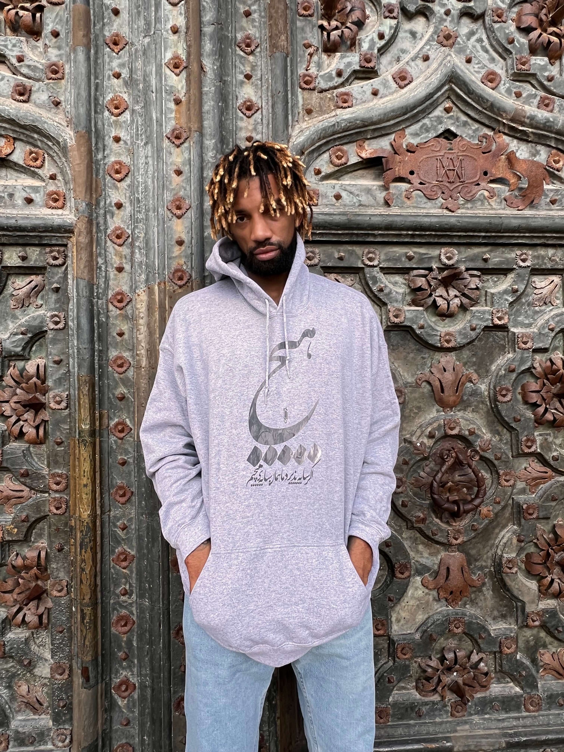 khem Birch is wearing Contemporary hoodie with a touch of Persian elegance, ideal for relaxation.