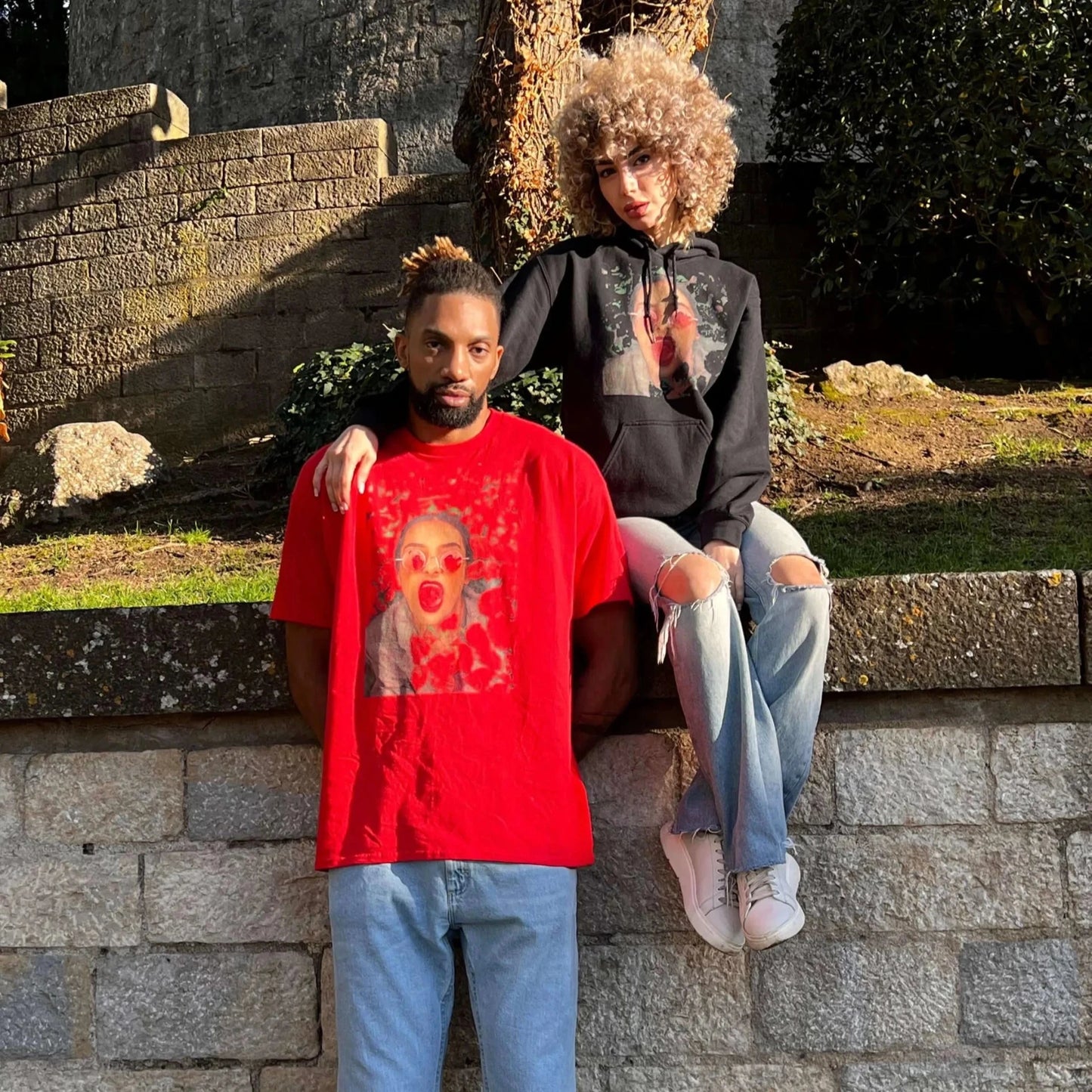 Red unisex graphic T-shirt featuring bold pop art design of woman with red sunglasses and tongue out, modern streetwear fashion