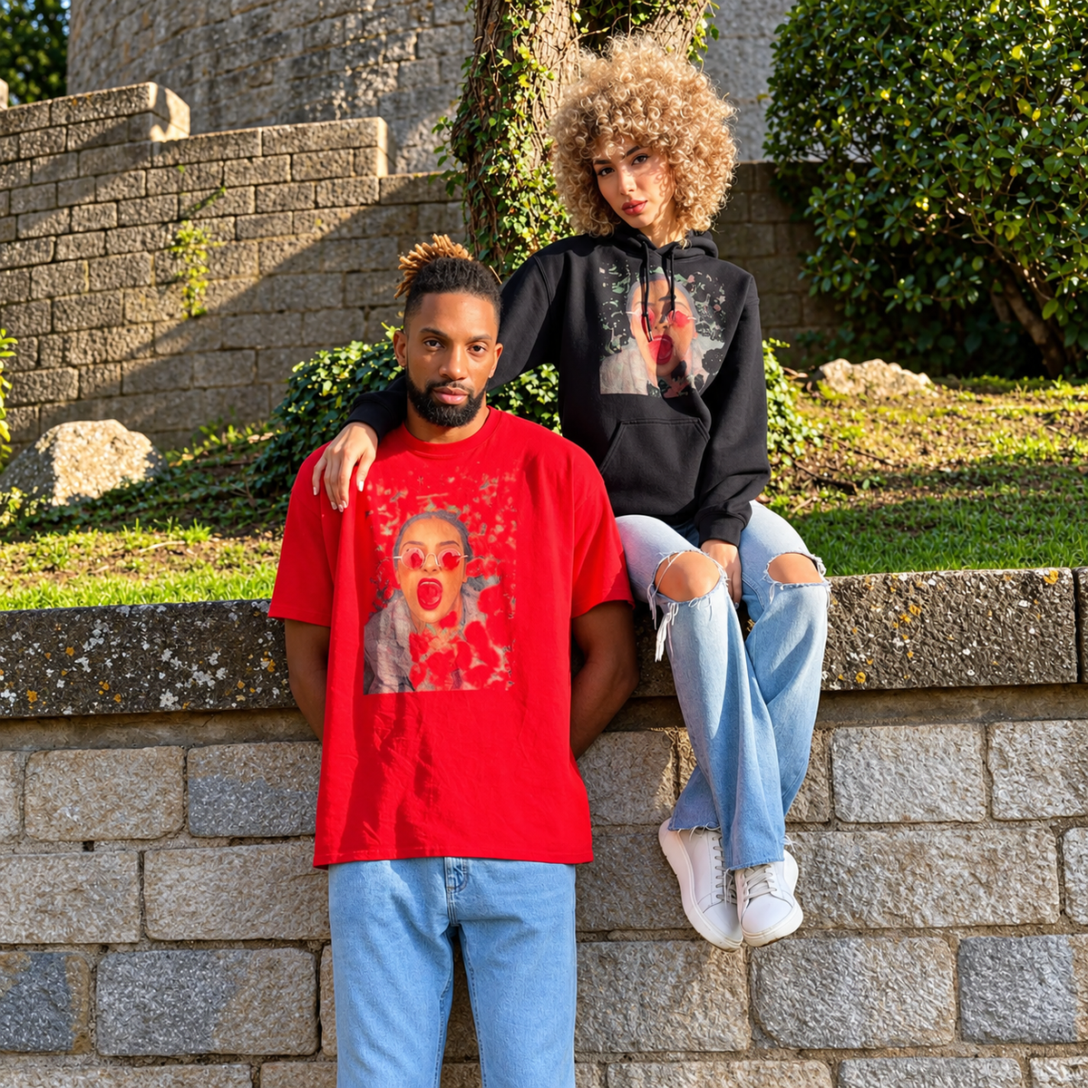 Khem birch wearing a red graphic T-shirt with a Salome Saliya model in a black graphic hoodie outdoors