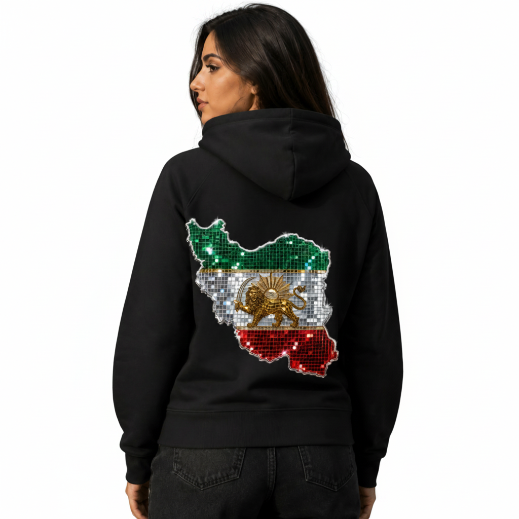 A woman wearing a black hoodie from the back, featuring a large map-shaped graphic of Iran filled with green, white, red, and gold sequins, set against a gray concrete background.