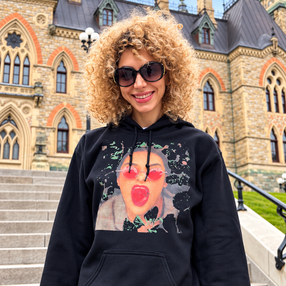 Woman wearing a black graphic hoodie with artistic portrait print in an outdoor lifestyle fashion photo