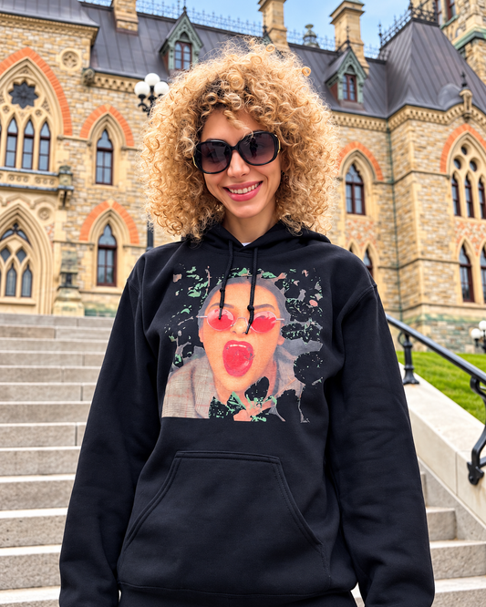 Woman wearing a black graphic hoodie with artistic portrait print in an outdoor lifestyle fashion photo
